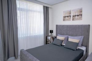a bedroom with a large bed and a window at ADIRAMA Apartments Elegant Apartments Walk to the Beach in Obzor