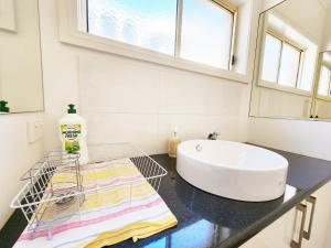 a bathroom with a tub and a sink on a counter at On The Beach, Kids & Pets Friendly in Frankston