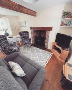 a living room with a couch and a fireplace at Bryn Goleu, Mersey Street, Borth-y-Gest in Porthmadog
