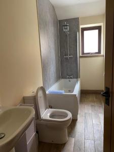 La salle de bains est pourvue de toilettes, d'une baignoire et d'un lavabo. dans l'établissement Wagtail Cottage, à Cloughton