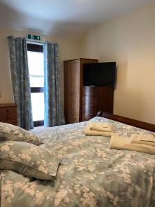 a bedroom with a bed and a flat screen tv at Wagtail Cottage in Cloughton