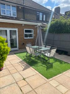 un patio con una mesa, sillas y una fuente. en Spacious 4 bedroom House with a Private Garden en Londres