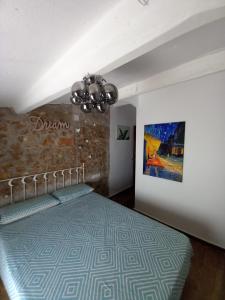 レス・カセス・ダルカナールにあるCasa Rositaのベッドルーム1室(ベッド1台付)が備わります。壁には絵画が飾られています。
