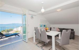a dining room with a table and chairs and a balcony at Awesome Apartment In Podaca With Kitchen in Podaca