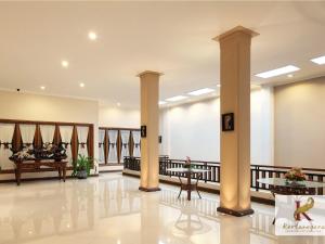 un hall d'un hôtel avec colonnes et table dans l'établissement Kertanegara Premium Guest House, à Malang