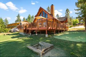 een groot houten huis met een groot terras bij 3 Cubs Lakefront - Stunning lakeside home with Hot Tub, Foosball, and Lake View in Big Bear Lake