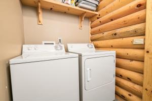2 wasmachines en een koelkast in een kamer met houten wanden bij 3 Cubs Lakefront - Stunning lakeside home with Hot Tub, Foosball, and Lake View in Big Bear Lake
