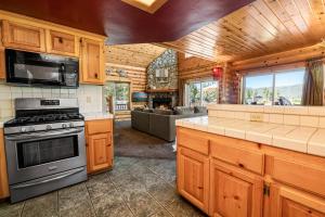 een keuken met een fornuis en een woonkamer bij 3 Cubs Lakefront - Stunning lakeside home with Hot Tub, Foosball, and Lake View in Big Bear Lake