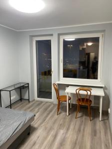 1 dormitorio con mesa, 2 sillas y ventana en Rajska 14B, en Gdansk