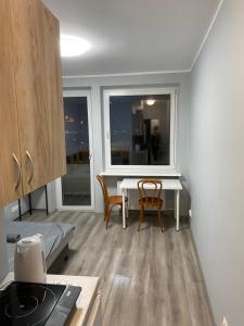 Habitación con mesa, sillas y ventana en Rajska 14B, en Gdansk