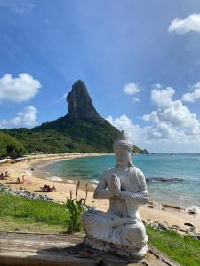 a statue of aitatingitating woman sitting on a beach at Pousada Luna in Fernando de Noronha