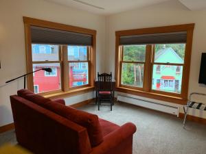 uma sala de estar com um sofá e três janelas em Inn At Creek Street em Ketchikan