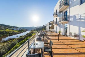 a balcony with tables and chairs overlooking a river at Beira Rio in Mértola