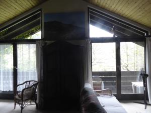 Schlafzimmer mit großen Fenstern und einem Bett in einem Zimmer in der Unterkunft Haus Wagner in Schiltach