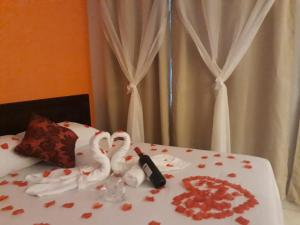 a bed with two swans and a bottle of wine at Parada Di Maria Guest House in Campos do Jordão