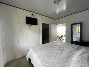 a bedroom with a bed and a television on the wall at Casa Felipe, lake view-cottage in Nuevo Arenal