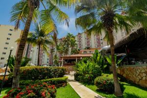 a resort with palm trees and flowers in a park at Hotsprings Suite Hotel in Caldas Novas