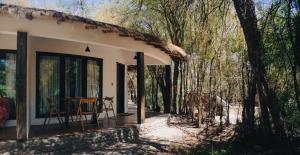 a cottage in the woods with a table on the porch at Lodge Atacama Horse in San Pedro de Atacama