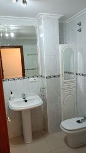 łazienka z umywalką, toaletą i lustrem w obiekcie APARTAMENTO AVELINA w mieście Monforte de Lemos