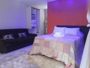 - une chambre avec un lit et un canapé dans l'établissement Parada Di Maria Guest House, à Campos do Jordão