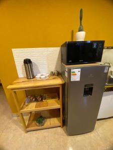 a microwave on top of a refrigerator next to a table at BROTHERs HOUSE II in Cusco