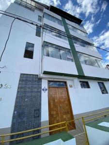 un edificio con una puerta de madera en su lateral en BROTHERs HOUSE II en Cuzco