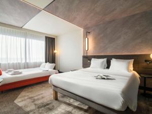 ein Hotelzimmer mit 2 Betten und einem Fenster in der Unterkunft Novotel Rotterdam Brainpark in Rotterdam