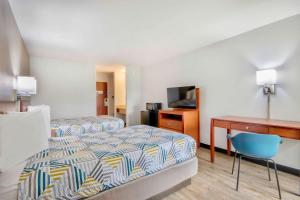 a hotel room with two beds and a desk at Motel 6-Abbeville, LA in Abbeville +16 photos