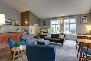 una sala de estar con sofás azules y una mesa. en Best Western Wesley Inn & Suites, en Gig Harbor