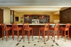 a bar with wooden chairs and a counter in a room at StayEasy Century City in Cape Town