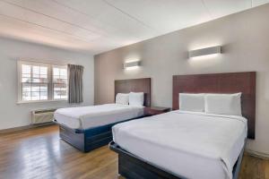 a hotel room with two beds and a window at Motel 6-Falls Church, VA - Arlington Boulevard in Falls Church