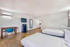 a hotel room with two beds and a chair at Motel 6-Falls Church, VA - Arlington Boulevard in Falls Church