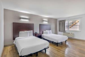a hotel room with two beds and a window at Motel 6-Falls Church, VA - Arlington Boulevard in Falls Church
