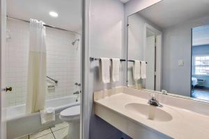 a bathroom with a sink and a toilet and a mirror at Motel 6-Falls Church, VA - Arlington Boulevard in Falls Church