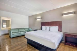 a hotel room with a bed and a couch at Motel 6-Falls Church, VA - Arlington Boulevard in Falls Church