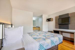 ein Hotelzimmer mit einem Bett und einem Flachbild-TV in der Unterkunft Motel 6 Bossier City, La in Bossier City