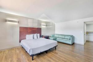 a large bedroom with a bed and a couch at Motel 6-Falls Church, VA - Arlington Boulevard in Falls Church
