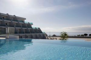 a large swimming pool in front of a building at Radisson Blu Resort, Lanzarote Adults Only in Costa Teguise