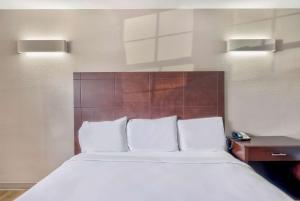 a bed with white pillows in a hotel room at Motel 6-Falls Church, VA - Arlington Boulevard in Falls Church