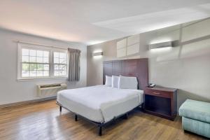 a bedroom with a large white bed and a window at Motel 6-Falls Church, VA - Arlington Boulevard in Falls Church