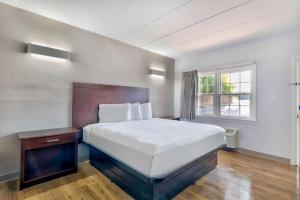 a bedroom with a large bed and a window at Motel 6-Falls Church, VA - Arlington Boulevard in Falls Church
