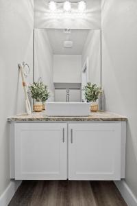 un bagno con un lavandino bianco e uno specchio di Beautiful New 3 Bedroom Townhouse w/ Private Pool a Corpus Christi Altre 23 foto