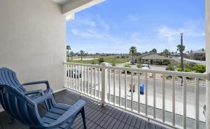 two blue chairs on a balcony with a view of the ocean at Beautiful New 3 Bedroom Townhouse w/ Private Pool in Corpus Christi