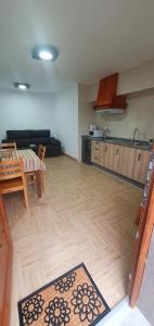 a living room with a table and a kitchen at ALOJAMIENTOS EL CASTRO in Taramundi