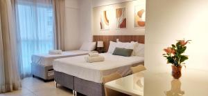 um quarto de hotel com duas camas e uma mesa em BSB Stay Premium - Flats Particulares - SHN em Brasília