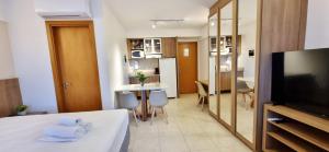 um quarto com uma cama, uma televisão e uma cozinha em BSB Stay Premium - Flats Particulares - SHN em Brasília