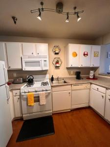 a kitchen with white cabinets and a stove top oven at Mario & Harry Potter Loft Universal Studios 10min loft apartment in Los Angeles