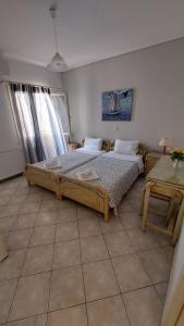 a bedroom with two beds and a table at Maria & Kyros House in Parga