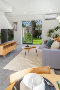sala de estar con sofá y TV en 2 bed Escape, Heart of Riccarton w/carpark en Christchurch