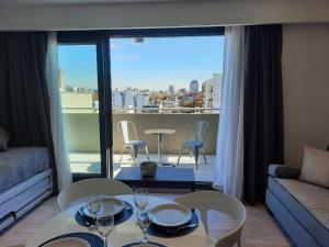 sala de estar con mesa y sillas y balcón en In House BA - Le coq en Buenos Aires